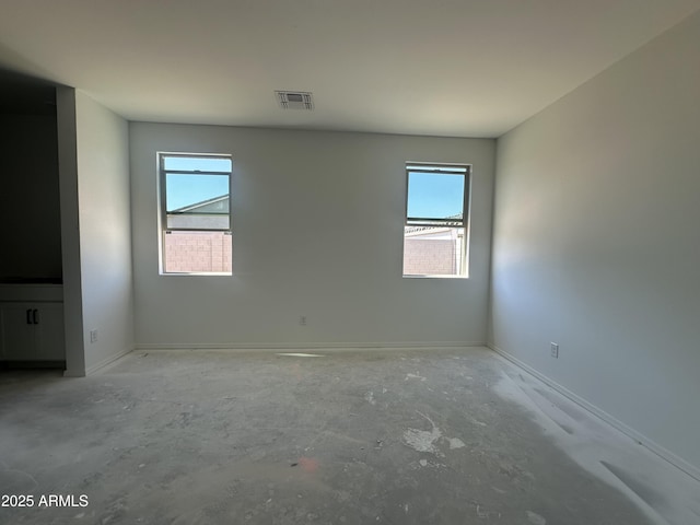 47230 W Cansados Rd, Maricopa, AZ 85139 - empty room featuring healthy amount of natural light, baseboards, and concrete flooring