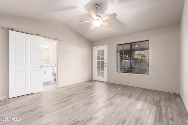 spare room featuring ceiling fan, light wood-type flooring, and vaulted ceiling