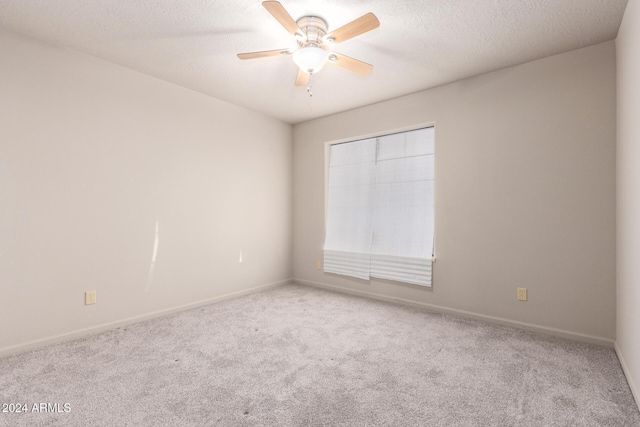 spare room featuring light carpet, a textured ceiling, and ceiling fan