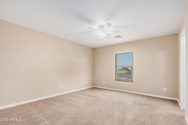 empty room featuring light carpet, a ceiling fan, visible vents, and baseboards