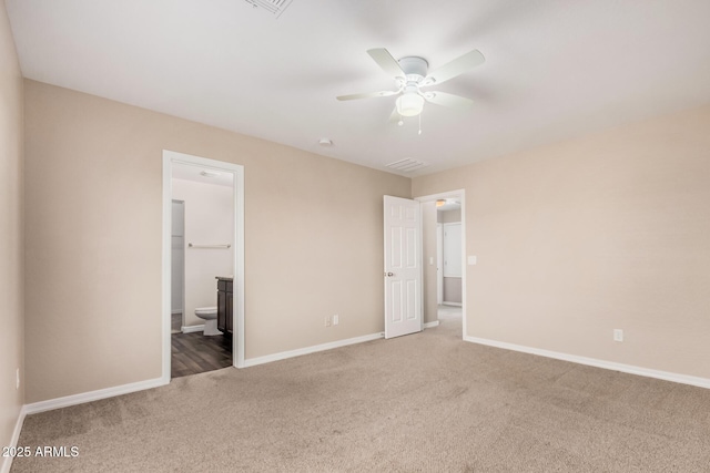 unfurnished bedroom with visible vents, a ceiling fan, connected bathroom, baseboards, and carpet flooring
