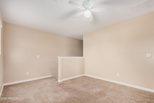 carpeted empty room with ceiling fan, baseboards, and visible vents