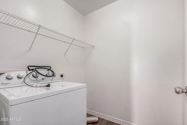clothes washing area with washer / dryer, dark wood-style flooring, laundry area, and baseboards