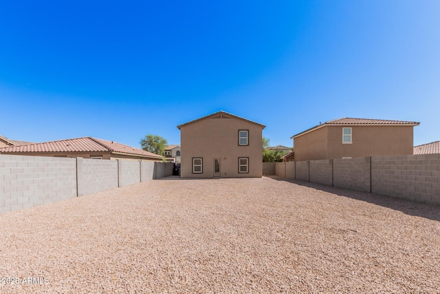 back of property with a fenced backyard and stucco siding