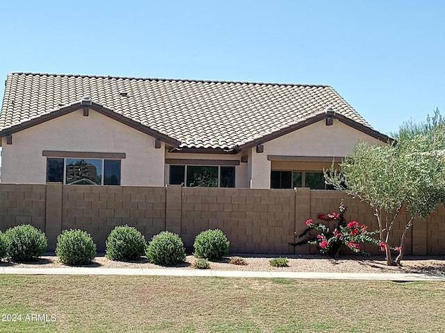 21042 E Camina Buena Vis, Queen Creek, AZ 85142 - view of home's exterior with a tiled roof, a lawn, stucco siding, and fence