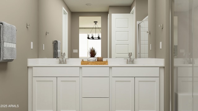 full bath featuring double vanity, an enclosed shower, a sink, and an inviting chandelier