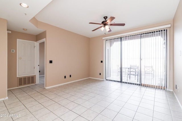 spare room with ceiling fan and light tile patterned floors