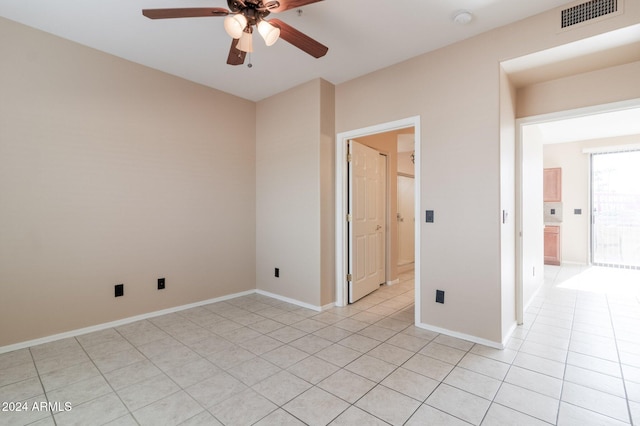 tiled empty room featuring ceiling fan