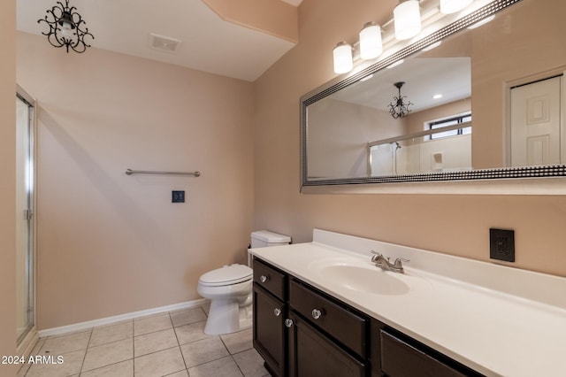 bathroom featuring toilet, an enclosed shower, vanity, and tile patterned floors