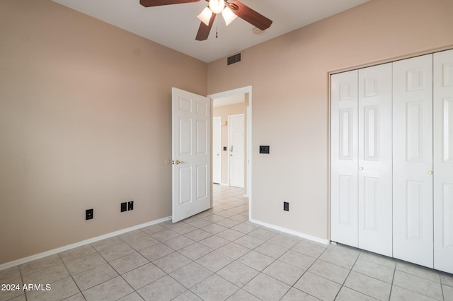 unfurnished bedroom with a closet, light tile patterned flooring, and ceiling fan