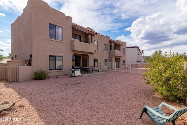 back of property with a balcony and a patio area