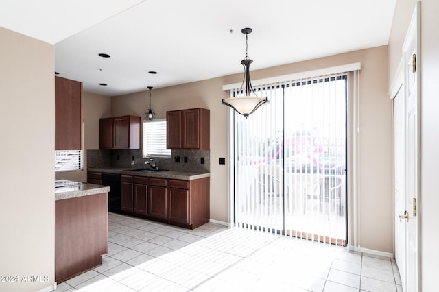 kitchen featuring decorative backsplash, dishwasher, hanging light fixtures, sink, and light tile patterned flooring