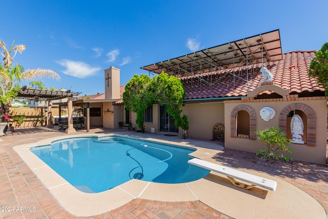 view of swimming pool featuring a patio area, a diving board, and a pergola