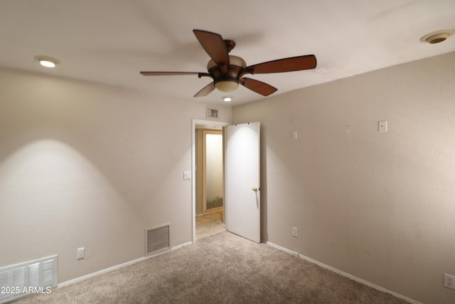 spare room with carpet floors, visible vents, and baseboards