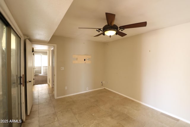 empty room with a ceiling fan and baseboards