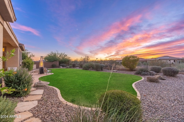 yard at dusk featuring a patio