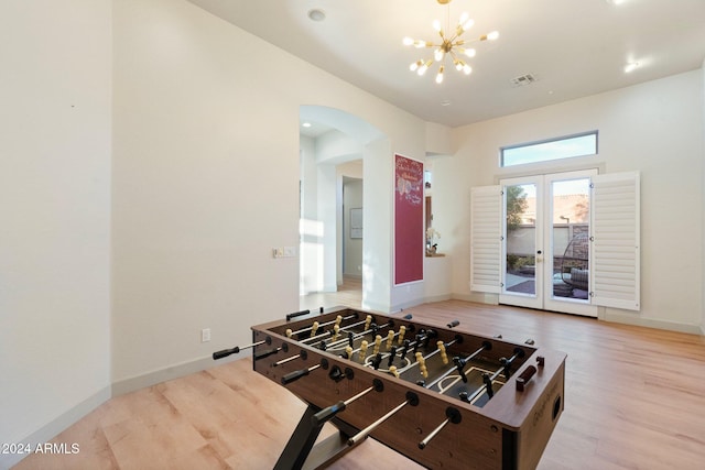 recreation room with wood-type flooring, french doors, and a notable chandelier