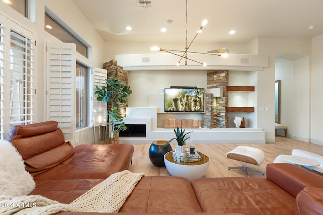 living room featuring an inviting chandelier, a healthy amount of sunlight, and light wood-type flooring