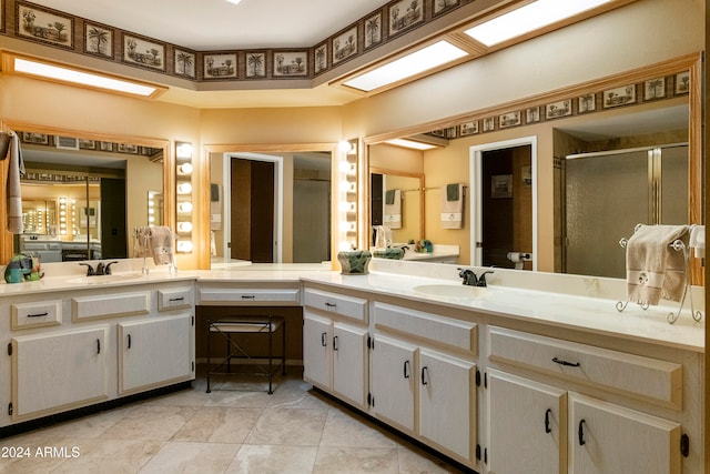 bathroom with a shower with door, vanity, and tile patterned flooring