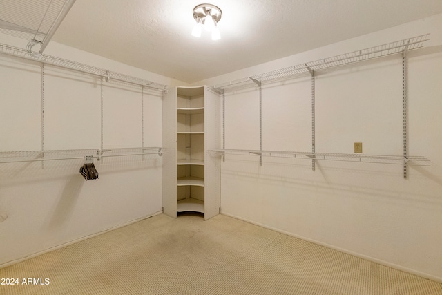 walk in closet featuring light carpet