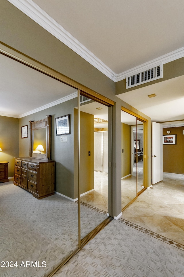 unfurnished bedroom with crown molding, a closet, and light carpet