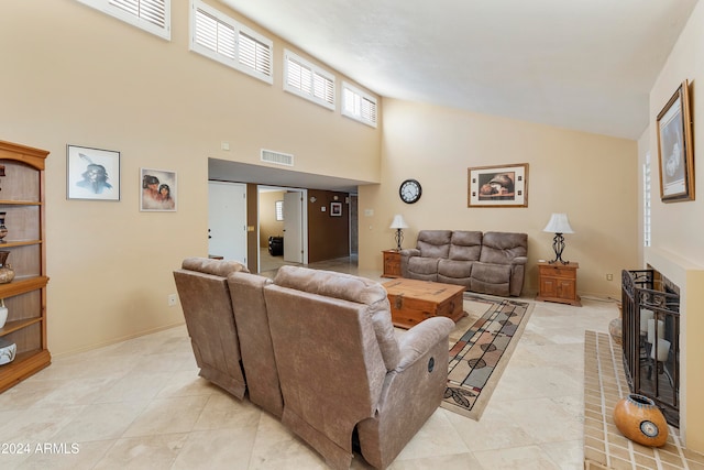 living room with high vaulted ceiling and light tile patterned floors