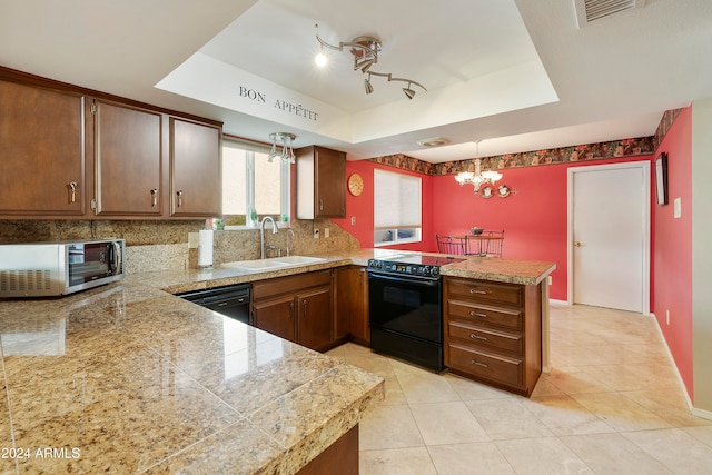 kitchen featuring sink, kitchen peninsula, decorative light fixtures, a tray ceiling, and black appliances