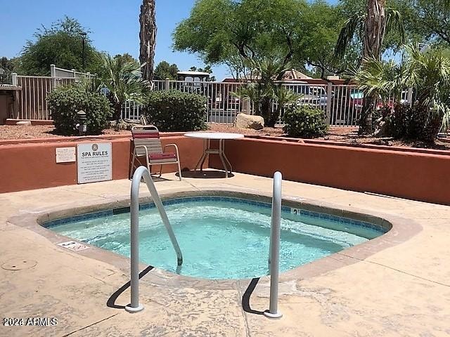 view of swimming pool with a community hot tub