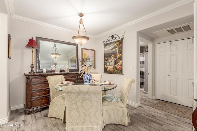 dining room featuring ornamental molding and light wood-type flooring