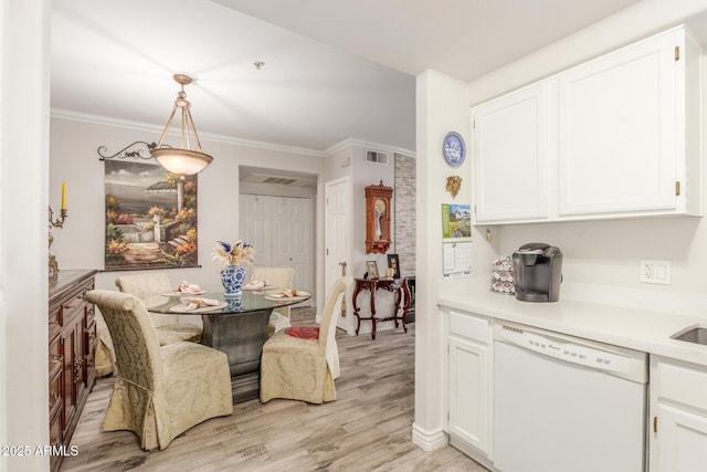 kitchen with dishwasher, white cabinets, hanging light fixtures, light hardwood / wood-style floors, and crown molding