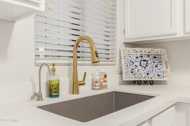 interior details with white cabinetry and sink