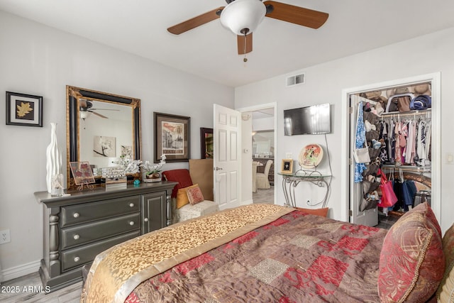 bedroom featuring ceiling fan, a walk in closet, a closet, and light wood-type flooring