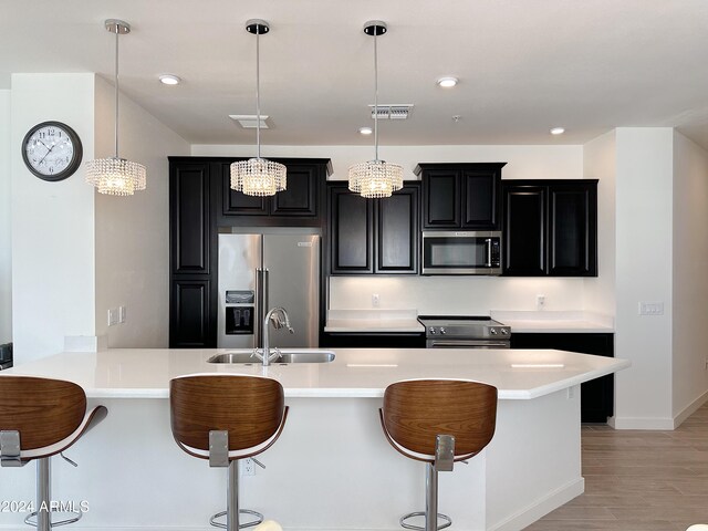 kitchen with high quality appliances, a breakfast bar area, and hanging light fixtures