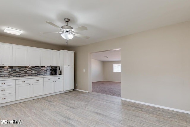 kitchen featuring backsplash, ceiling fan, light hardwood / wood-style flooring, and white cabinets