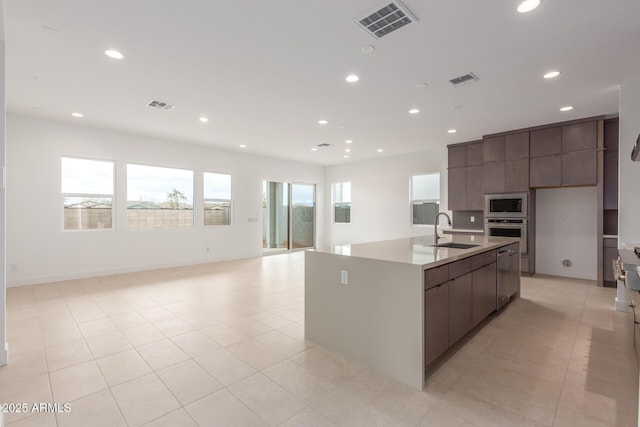 kitchen with stainless steel appliances, visible vents, a sink, and modern cabinets