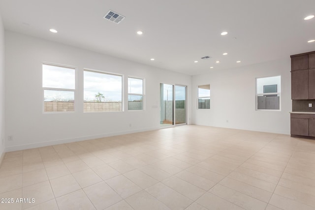 unfurnished living room with baseboards, light tile patterned flooring, visible vents, and recessed lighting