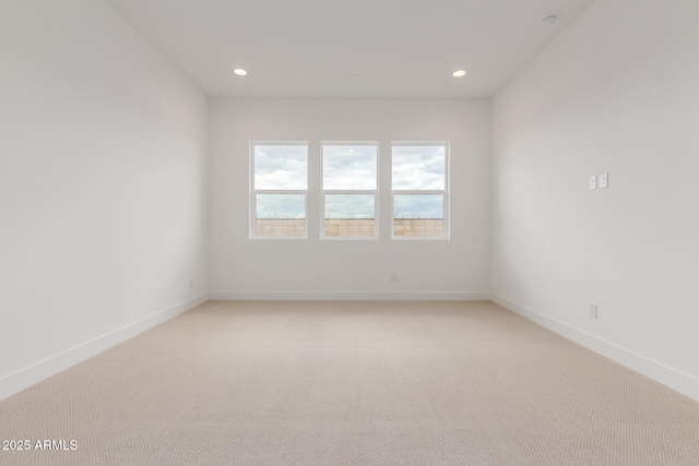 spare room featuring light carpet, baseboards, and recessed lighting