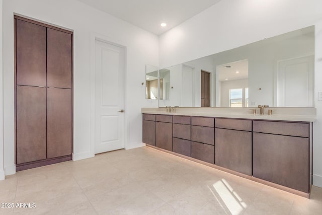 bathroom featuring double vanity, a sink, and recessed lighting