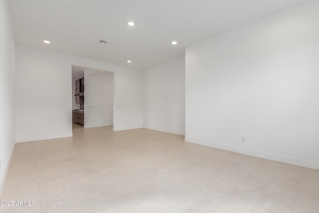 empty room with recessed lighting, visible vents, and baseboards