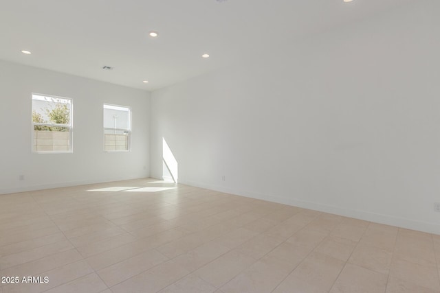 empty room featuring baseboards and recessed lighting