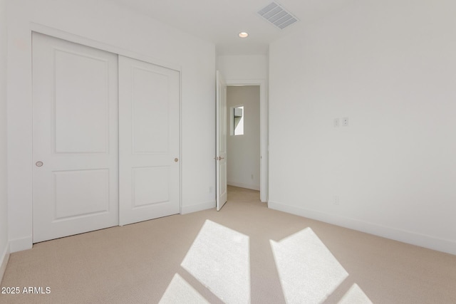 unfurnished bedroom featuring light carpet, baseboards, visible vents, a closet, and recessed lighting