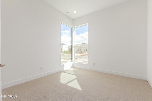 empty room featuring carpet, baseboards, and recessed lighting