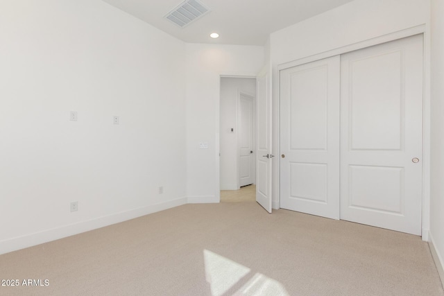 unfurnished bedroom with recessed lighting, light colored carpet, visible vents, baseboards, and a closet