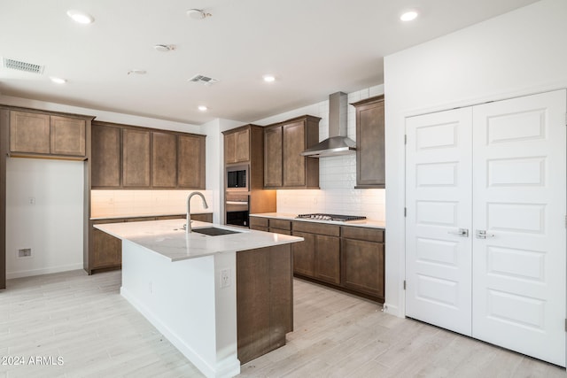 27271 N 73rd Ln, Peoria, AZ 85383 - kitchen with wall chimney range hood, a sink, stainless steel appliances, backsplash, and light wood finished floors