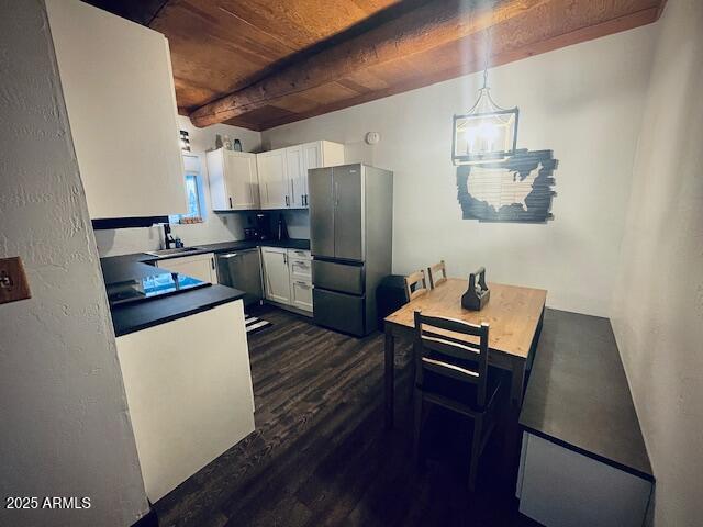 kitchen featuring dark hardwood / wood-style flooring, stainless steel appliances, wooden ceiling, white cabinetry, and hanging light fixtures