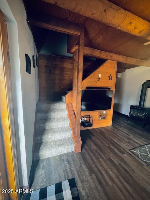 stairway with beam ceiling, wood ceiling, and hardwood / wood-style flooring