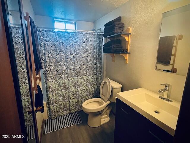 bathroom with hardwood / wood-style floors, vanity, and toilet