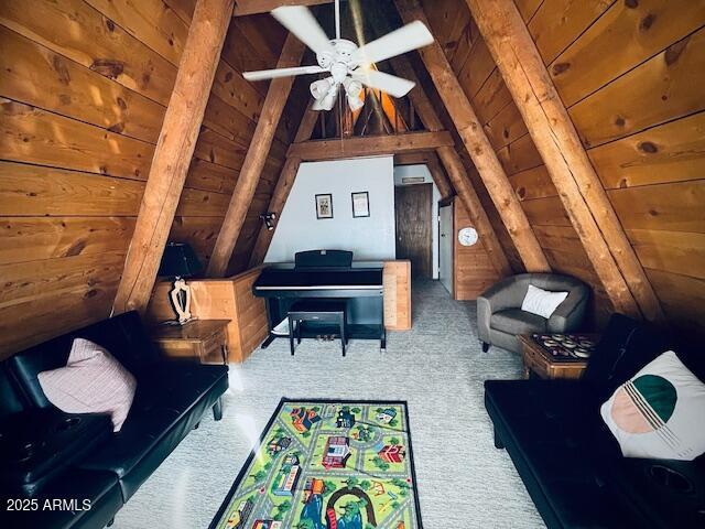 carpeted living room featuring lofted ceiling with beams, ceiling fan, wood ceiling, and wood walls