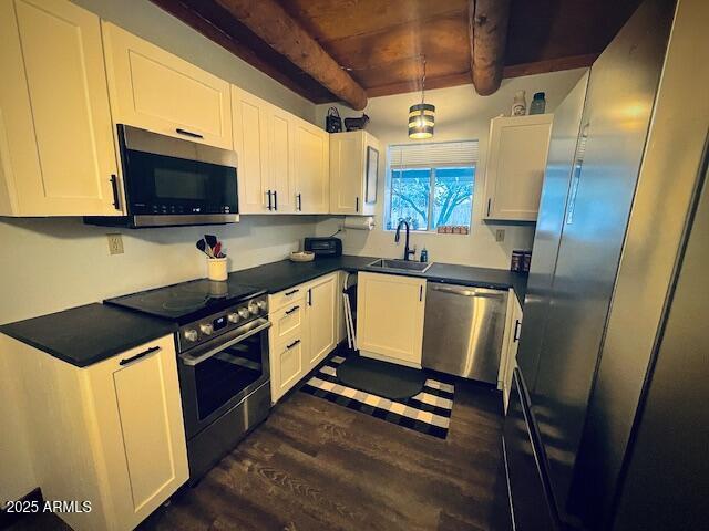 kitchen featuring sink, white cabinetry, appliances with stainless steel finishes, beam ceiling, and wood ceiling