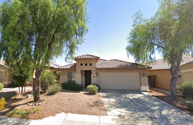 mediterranean / spanish-style home with a garage, a tile roof, and stucco siding